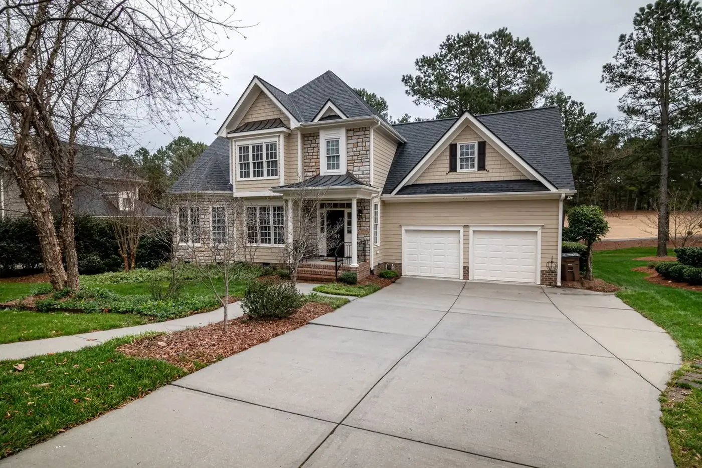 Two-story suburban home with a wide concrete driveway leading to a two-car garage