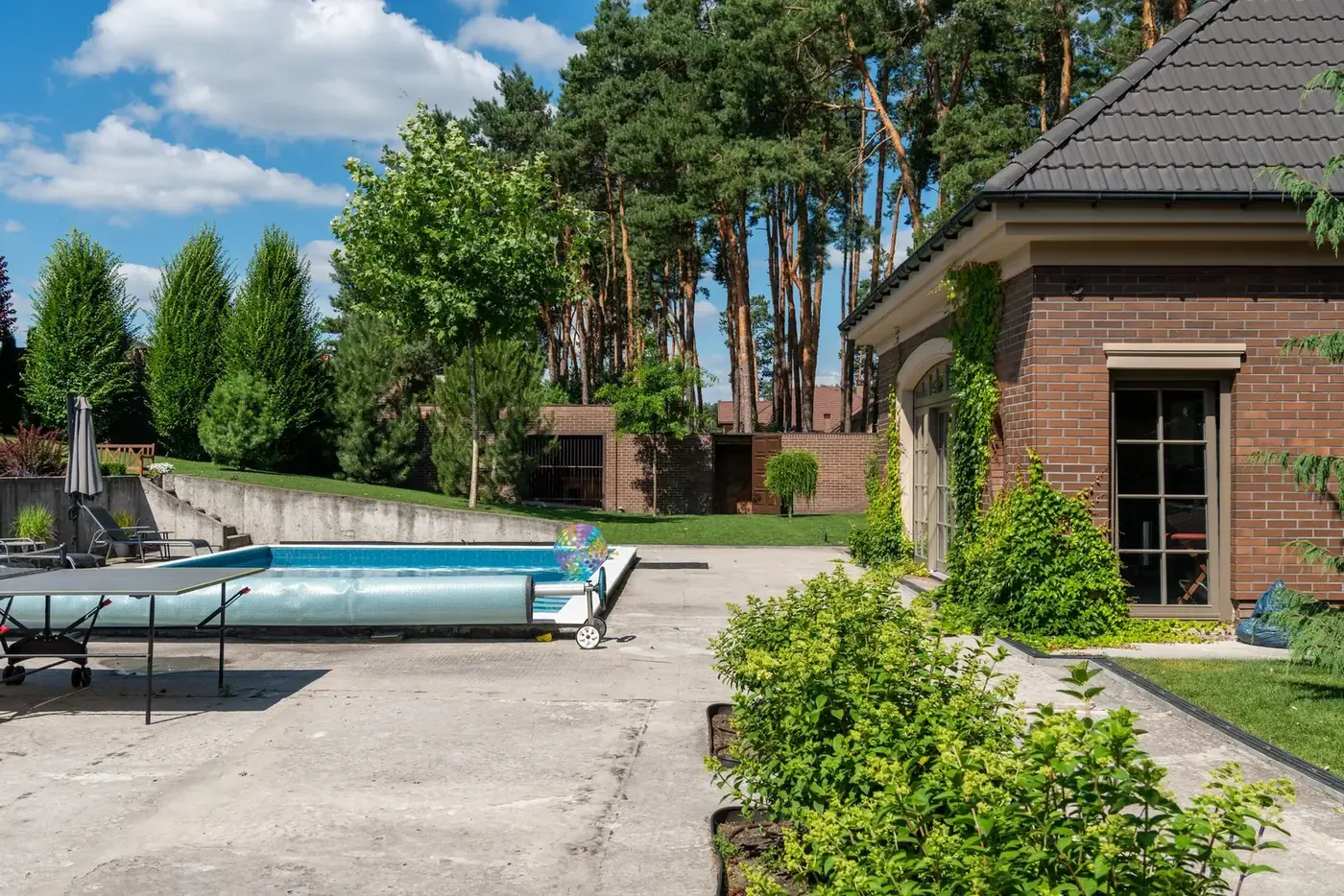 Concrete pool deck around a backyard in-ground swimming pool